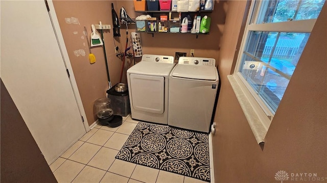 washroom with washing machine and clothes dryer and light tile patterned floors