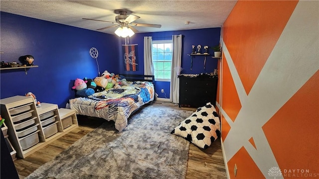 bedroom featuring a textured ceiling, ceiling fan, and hardwood / wood-style floors