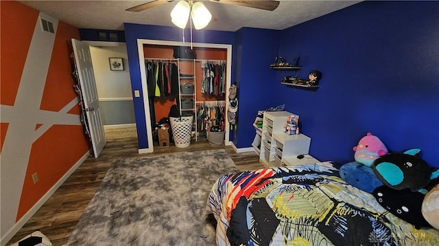 bedroom with a textured ceiling, ceiling fan, a closet, and dark hardwood / wood-style floors