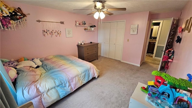 carpeted bedroom with ceiling fan, a closet, and a textured ceiling