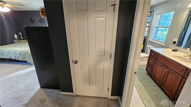 bathroom with toilet, ceiling fan, and vanity