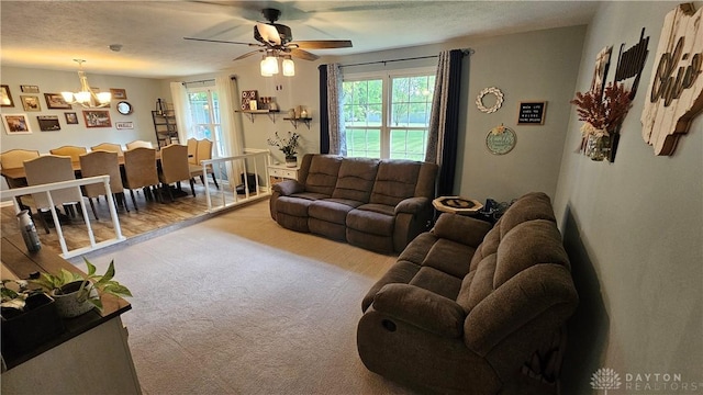 living room with light colored carpet and ceiling fan with notable chandelier