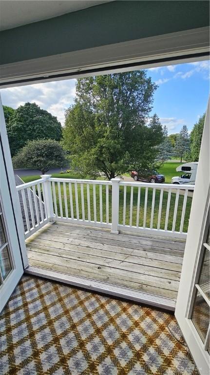 wooden deck featuring a lawn