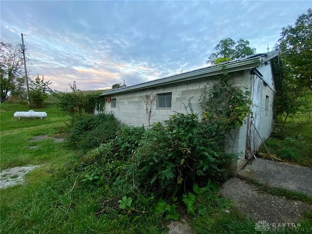 view of side of property featuring a garage and a lawn