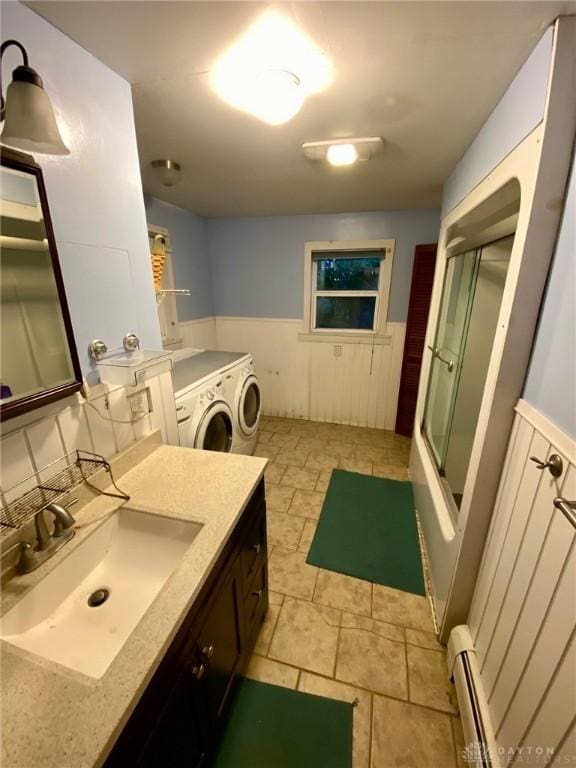 2586 State Route 763, Aberdeen, OH 45101 - bathroom with a baseboard heating unit, vanity, a wainscoted wall, bath / shower combo with glass door, and washing machine and clothes dryer