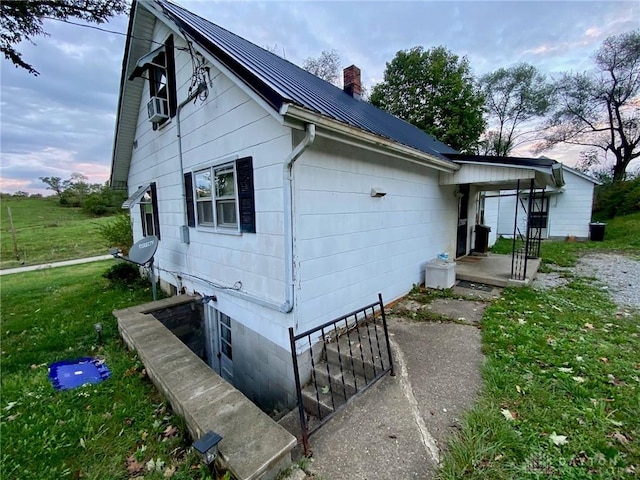 2586 State Route 763, Aberdeen, OH 45101 - view of property exterior featuring a chimney, metal roof, and a lawn