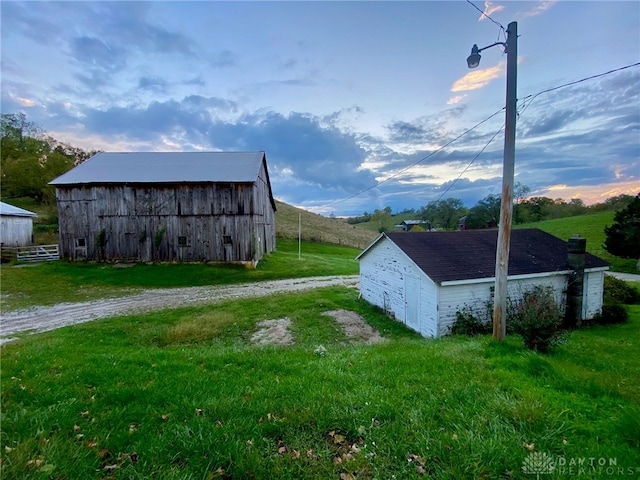 outdoor structure at dusk featuring a yard