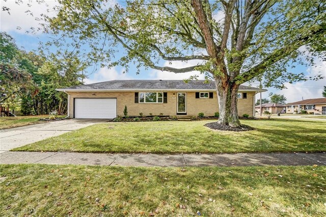 single story home with a front yard and a garage