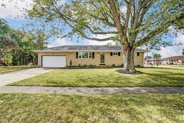 ranch-style home featuring a garage, brick siding, driveway, and a front yard