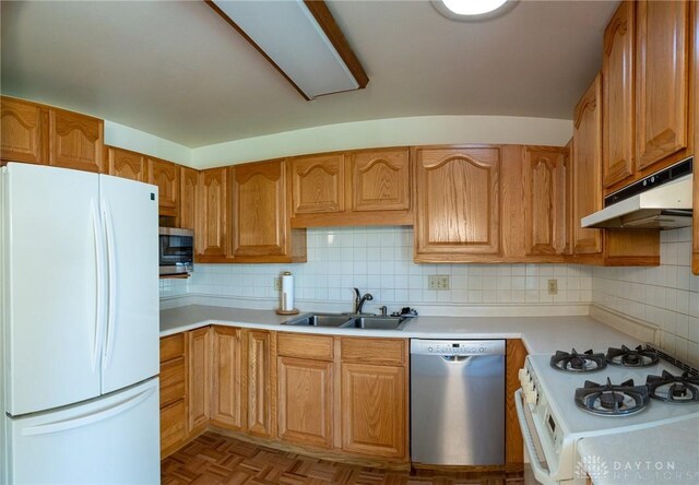 kitchen featuring backsplash, light parquet floors, appliances with stainless steel finishes, and sink