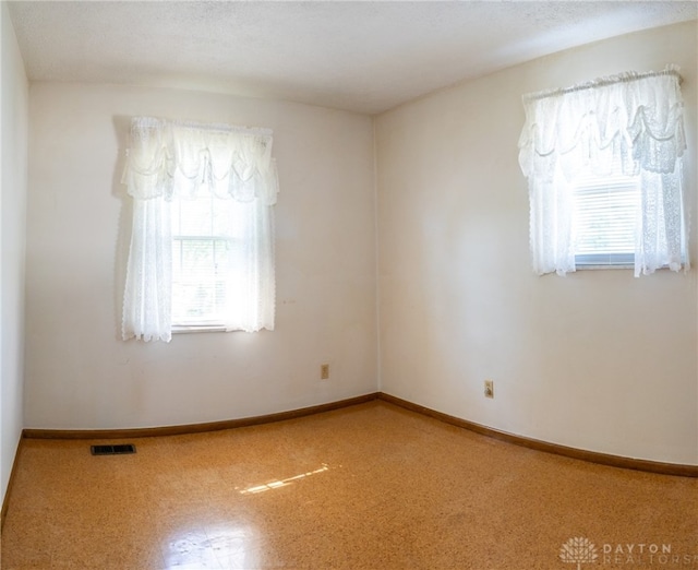 unfurnished room featuring a wealth of natural light