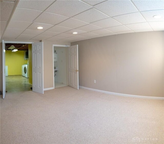 basement with carpet, washing machine and clothes dryer, and a paneled ceiling