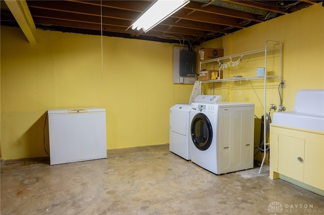 clothes washing area with electric panel and separate washer and dryer