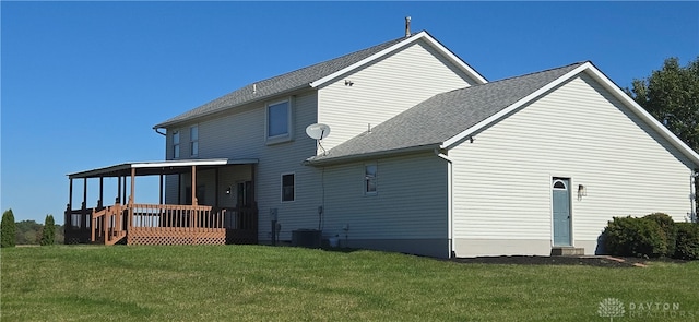 rear view of property featuring a yard, a deck, and central AC unit