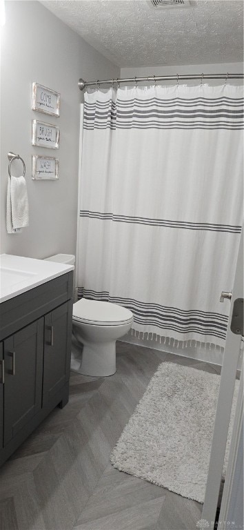 bathroom featuring vanity, a textured ceiling, curtained shower, and toilet