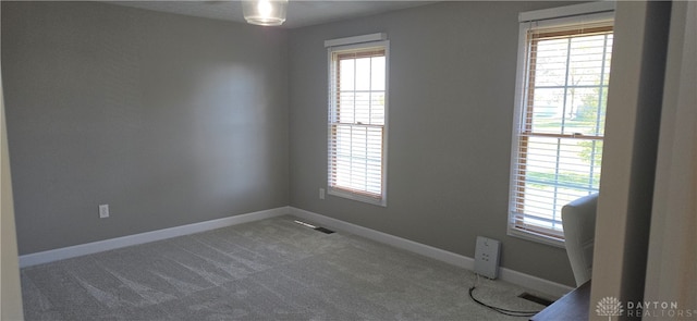 empty room with carpet floors and a healthy amount of sunlight