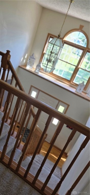 stairs with an inviting chandelier