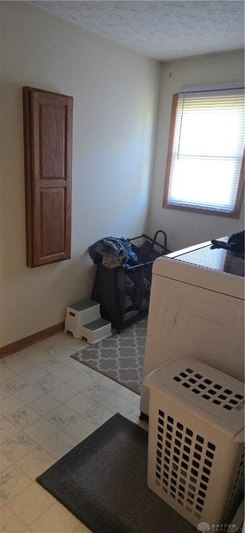 bedroom with a textured ceiling and washer / clothes dryer