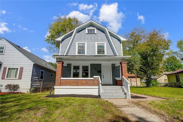 view of property featuring a porch and a front lawn