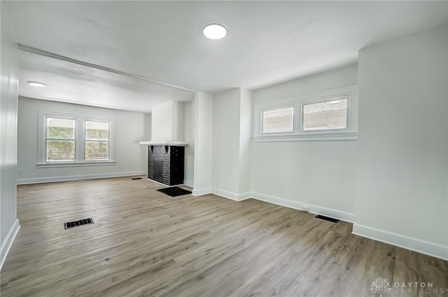 unfurnished living room with a fireplace and light hardwood / wood-style flooring