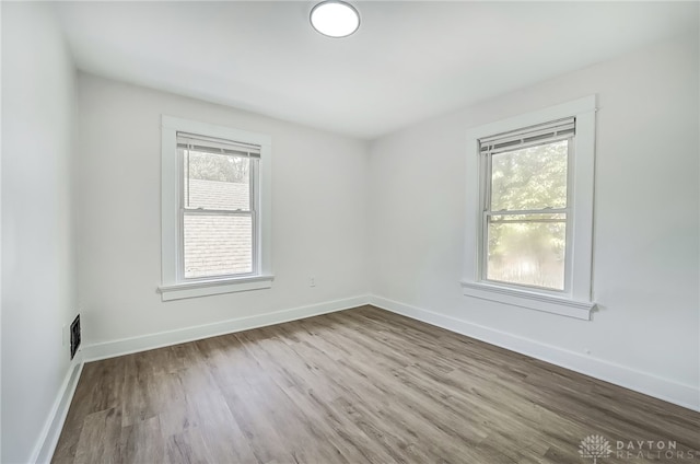 unfurnished room with hardwood / wood-style flooring and a wealth of natural light