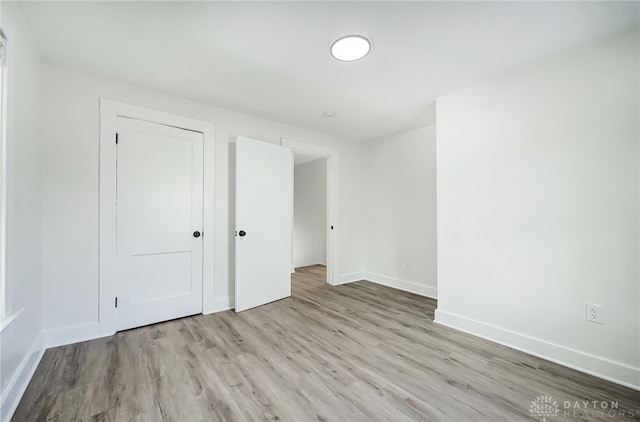 unfurnished bedroom featuring light wood-type flooring and a closet