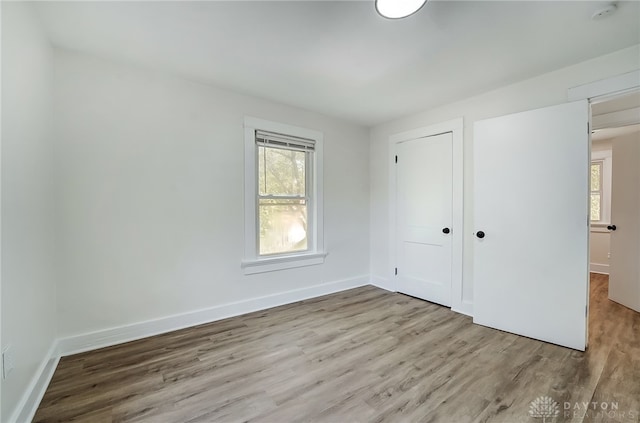 unfurnished bedroom featuring light wood-type flooring and a closet