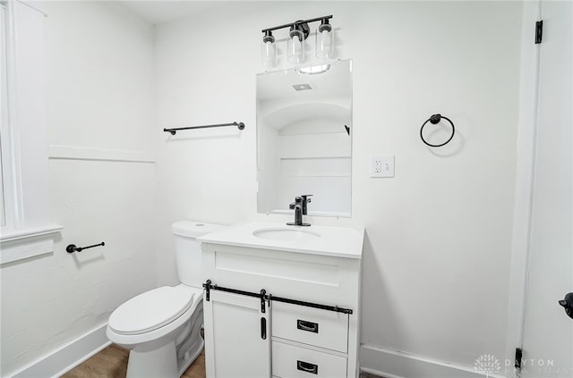 bathroom with wood-type flooring, vanity, and toilet