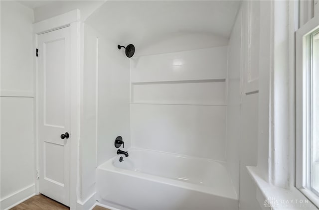 bathroom featuring wood-type flooring and shower / washtub combination