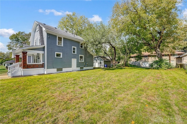 rear view of house featuring a yard and a porch