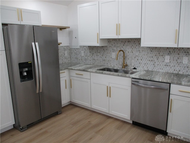 kitchen with light hardwood / wood-style floors, stainless steel appliances, sink, and white cabinetry