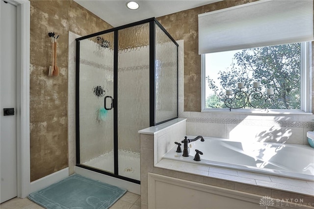 bathroom with separate shower and tub and tile patterned flooring