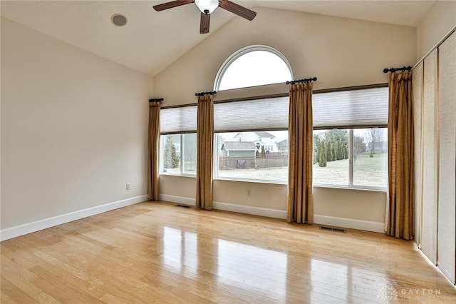 empty room featuring ceiling fan, lofted ceiling, and light wood-type flooring