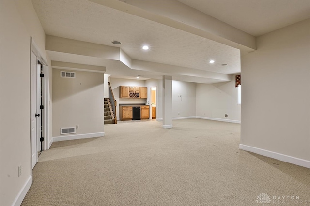 basement featuring light colored carpet and a textured ceiling