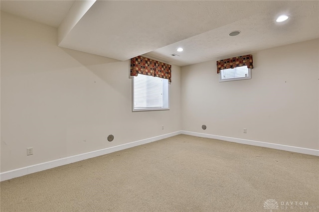 basement featuring carpet flooring and a textured ceiling