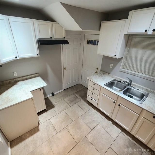 kitchen featuring white cabinets, light tile patterned floors, light stone counters, and sink