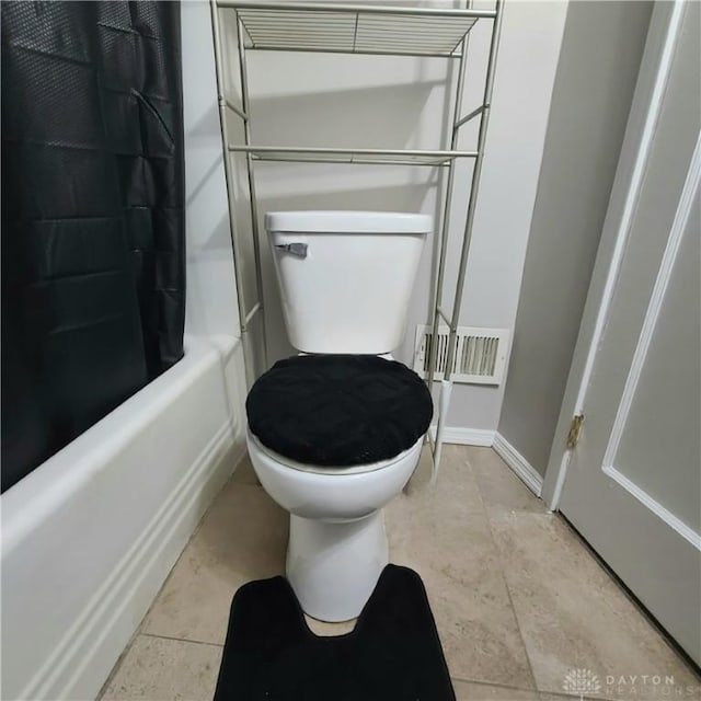 bathroom with shower / bath combo and toilet