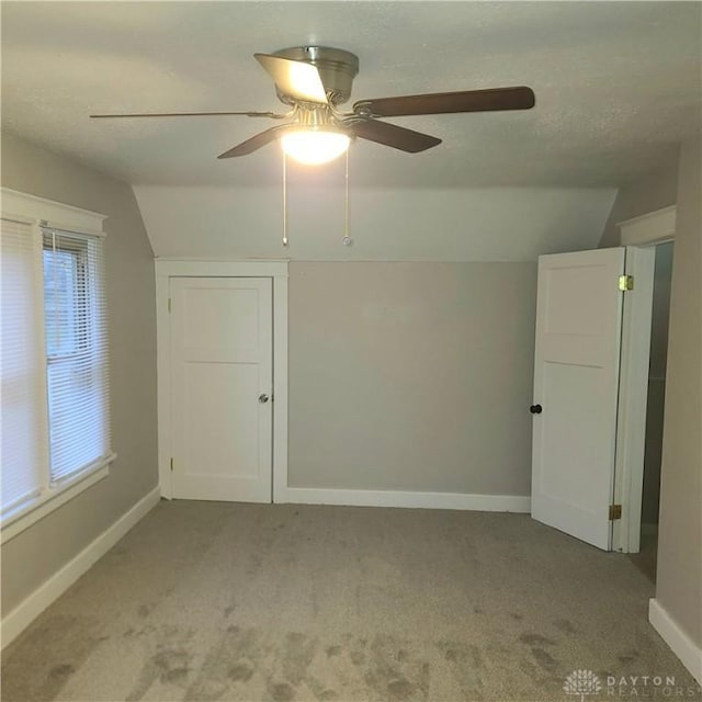 additional living space featuring ceiling fan, light carpet, and vaulted ceiling