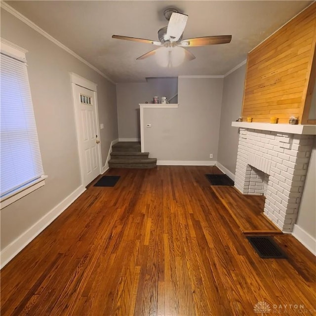 unfurnished living room featuring a fireplace, dark hardwood / wood-style floors, ceiling fan, and ornamental molding