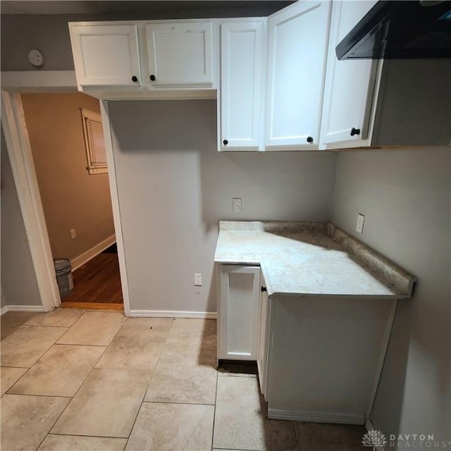 kitchen featuring white cabinetry, light tile patterned floors, and exhaust hood