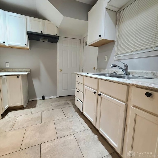 kitchen featuring white cabinetry, sink, and light tile patterned floors