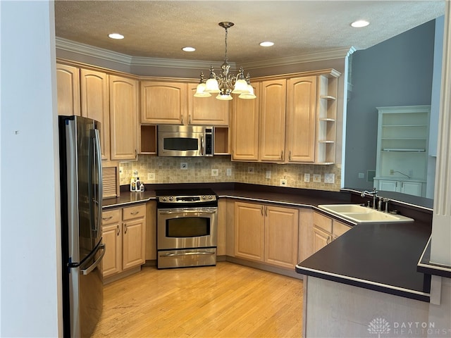 kitchen with sink, a textured ceiling, decorative light fixtures, light hardwood / wood-style flooring, and appliances with stainless steel finishes