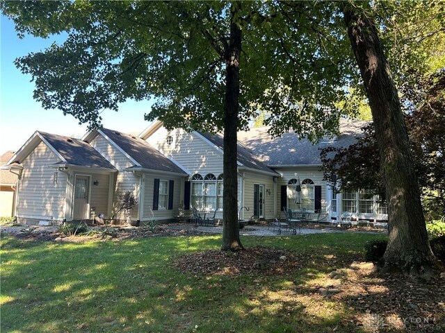 rear view of property featuring a lawn