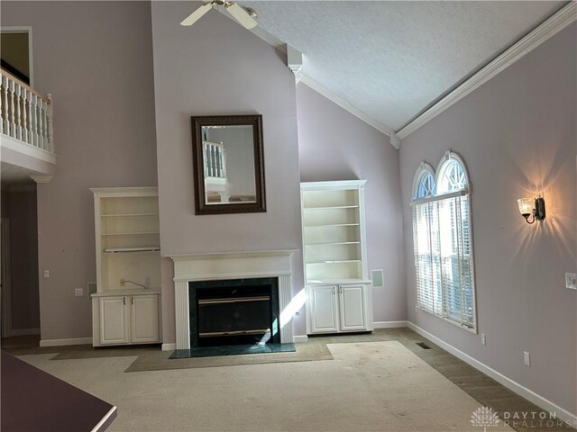 unfurnished living room featuring ceiling fan, light carpet, ornamental molding, high vaulted ceiling, and a textured ceiling