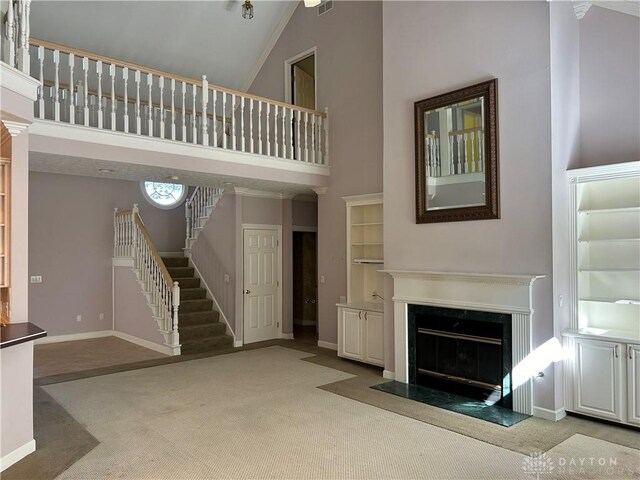 unfurnished living room featuring high vaulted ceiling and light colored carpet