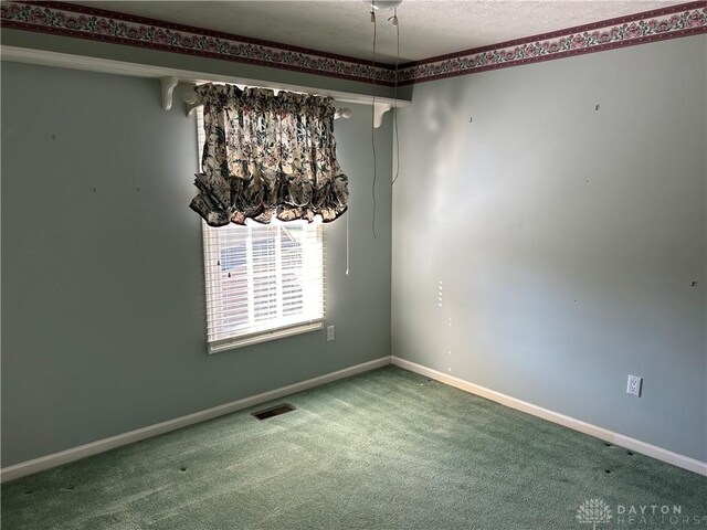 carpeted empty room featuring a textured ceiling