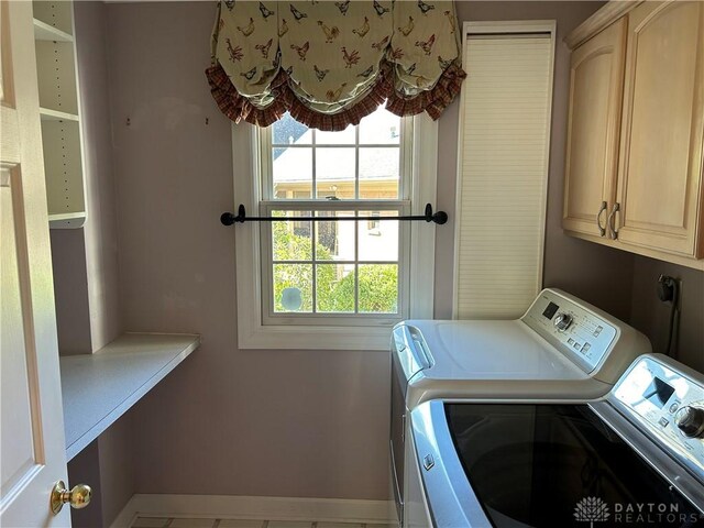 washroom featuring washer and clothes dryer and cabinets