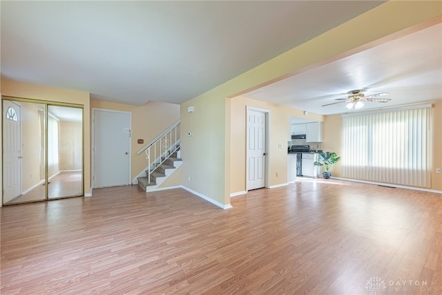 unfurnished living room featuring ceiling fan and light hardwood / wood-style floors