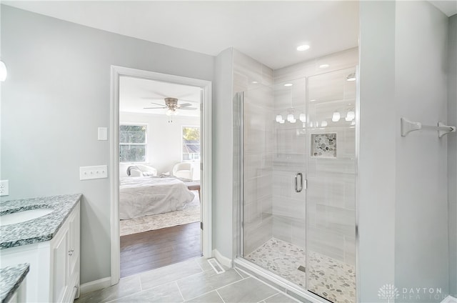 bathroom featuring a shower with door, vanity, wood-type flooring, and ceiling fan