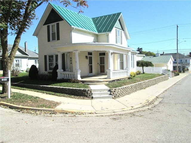 204 N Main St, Lewisburg, OH 45338 - view of front of house featuring a porch, a standing seam roof, metal roof, and fence
